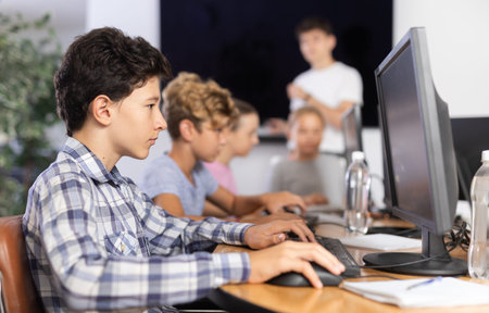 Boy student learning to work on computer in classroom