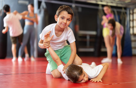 Purposeful engrossed boy and girl train during self-defense fight training session in gymの写真素材