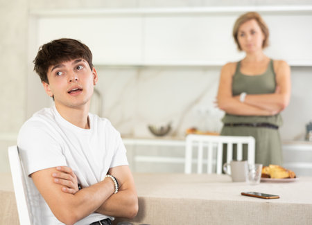Angry woman swears at young guy, family quarrel.の写真素材