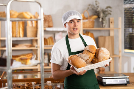 male baker sells croissants, shows off a variety of crescent-shaped buns.