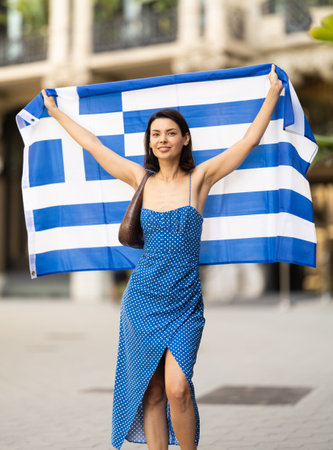 Young woman with Greek flag on city streetの写真素材