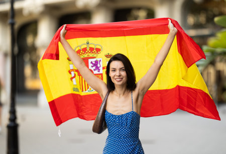 Young woman with spanish flag on city streetの写真素材