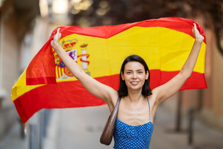 Young woman with spanish flag on city streetの写真素材
