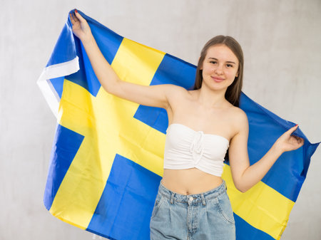 Young woman with Sweden flag posing in studioの写真素材