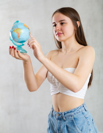 Portrait of young student girl with a globe in her handsの写真素材