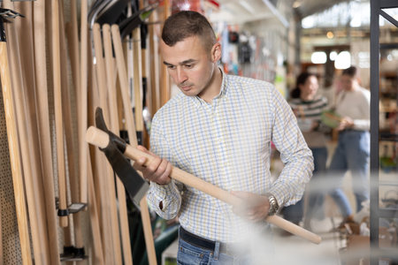 Young man choosing hoe in storeの写真素材