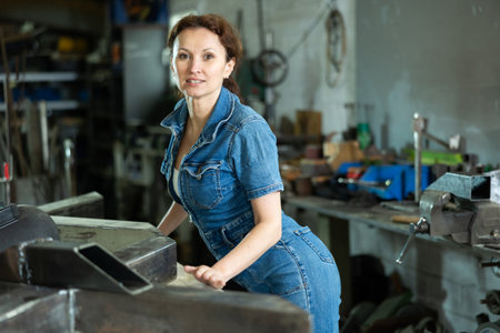 Portrait of confident female worker in workshop of metallurgical plantの写真素材