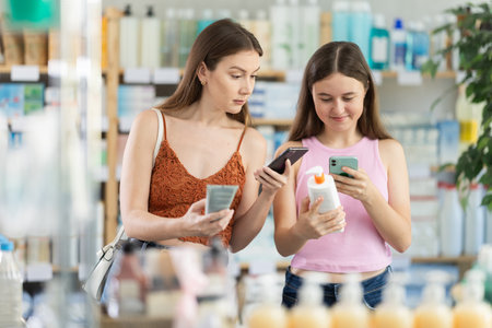 Woman with daughter scanning qr code of creamの写真素材