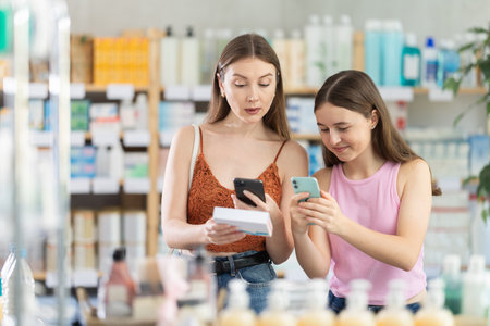 Daughter and mother in summer clothes scans code on pills to check expiration dateの写真素材