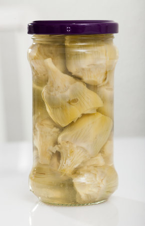 Glass jar with tasty preserved artichokes on table, nobodyの写真素材