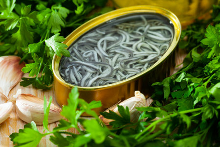 Pickled eels on background with garlic and greens at tableの写真素材