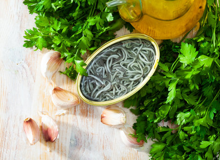 Pickled angoulas in tin can with garlic and parsley.の写真素材