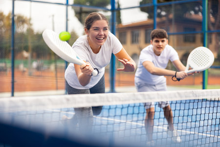 Young sporty couple playing paddle tennis outdoorsの写真素材
