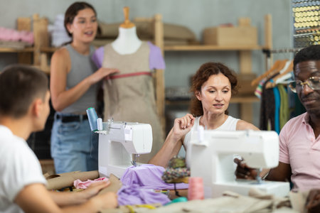 Participants in coterie practice sewing, chatting and talking, work with mannequinの写真素材
