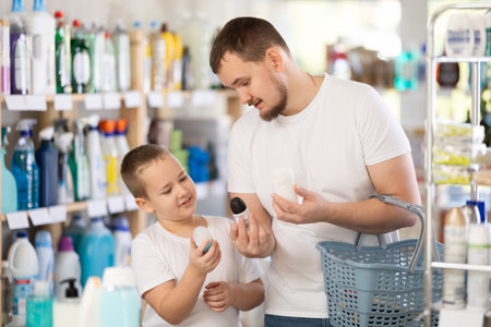 Man and boy choosing deodorant in storeの写真素材
