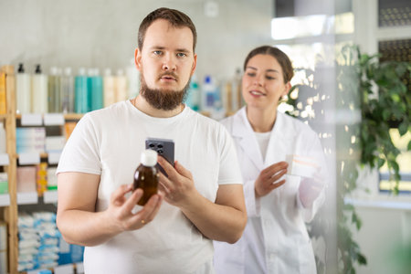 Man buyer scans syrup qr code with woman pharmacistの写真素材