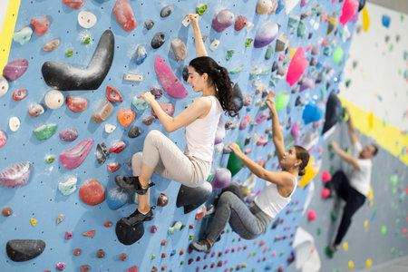 Young woman doing rock climbing on climbing wallの写真素材