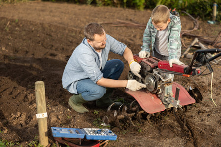 Man and his son are repairing garden equipmentの写真素材
