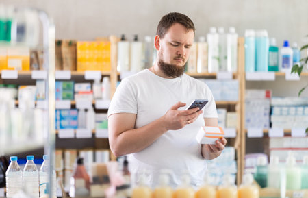 Young man scanning qr code of pillsの写真素材