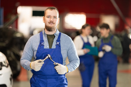 Smiling car service employee with toolsの写真素材