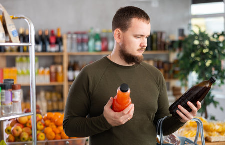 Grocery shopping - man chooses juice in supermarketの写真素材