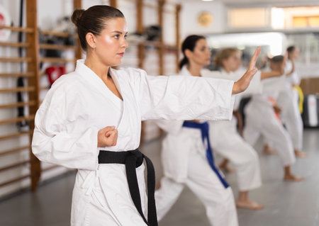 Women practice fighting stances during karateの写真素材
