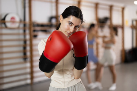 Woman in red boxing gloves in gymの写真素材