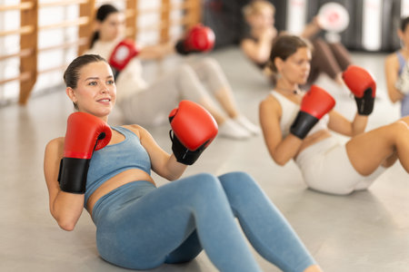 women doing abdominal exercise in boxing gloves