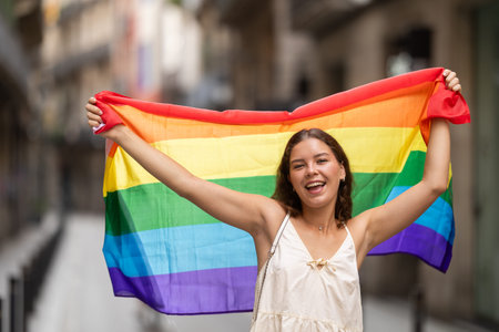 Young woman with LGBT flag on city street