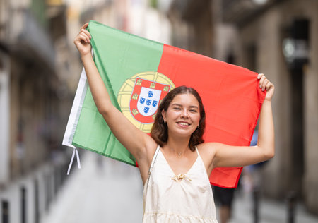 Young woman with Portuguese flag on city streetの写真素材