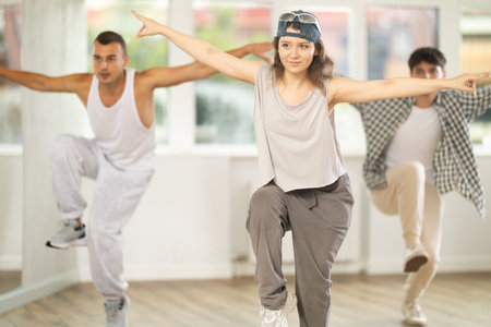 Group of young hip-hop dancers rehearsing in studio. Dancers full of energy