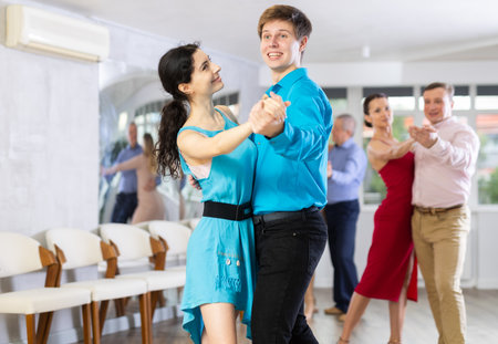 Guy and woman enjoying slow foxtrot as couple in dance studioの写真素材