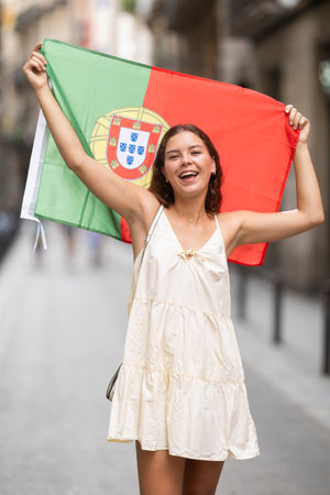 Young woman with Portuguese flag on city streetの写真素材