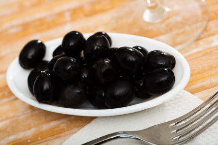 Pitted black olives in white plateの写真素材