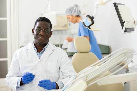 Smiling african american dentist posing in dental clinic officeの写真素材