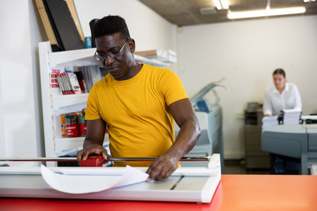 Employee of printing house checks the quality of printing in computer roomの写真素材