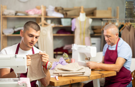 Two male tailors working with fabric