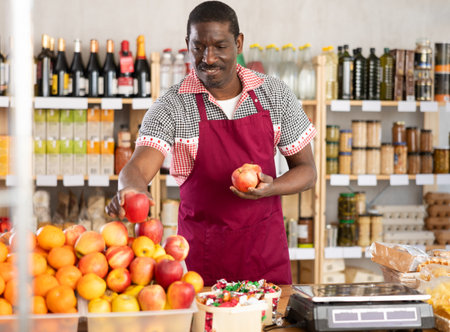 African man seller stands and work in trading hall of storeの写真素材