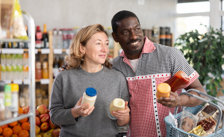 Couple buying various sauces and mayonnaise in grocery supermarketの写真素材