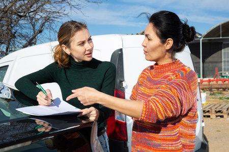 Woman signs the documents for the delivery of the goods to farm fieldの写真素材