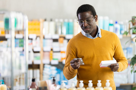 Adult man chooses pills at pharmacyの写真素材