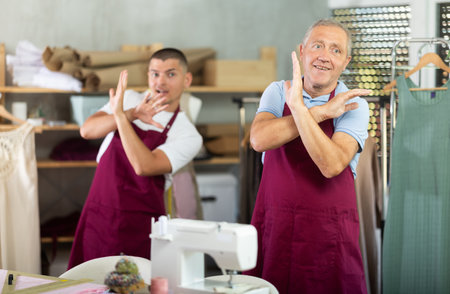 Male tailors doing a warm-up at workの写真素材