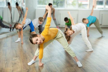 Girl learn to dance hip hop dances, doing movement with unrecognizable teacher.の写真素材