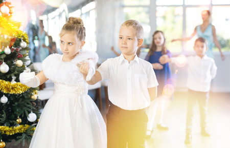 Christmas ball - group of children in festive clothes dances a waltz around New Year treeの写真素材