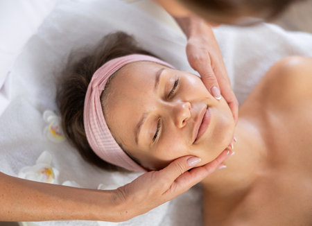 Young woman getting facial massage in salonの写真素材