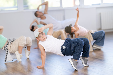 Preteen boys and girls studying movement of contemporary dance in classroom with his friendsの写真素材