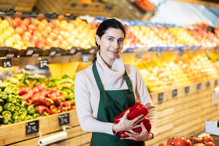 Woman seller offering bell peppers