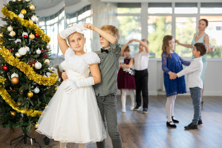 Viennese waltz performed by beautifully dressed children near Christmas treeの写真素材