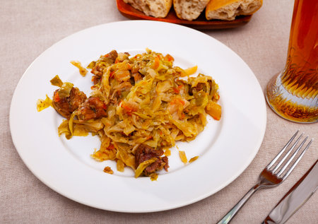 Appetizing cabbage stewed with pork meat on white plateの写真素材