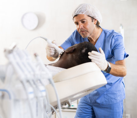Professional aesthetician administering high frequency ultrasound facial procedure on manの写真素材